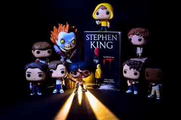 a group of action figures standing next to a book