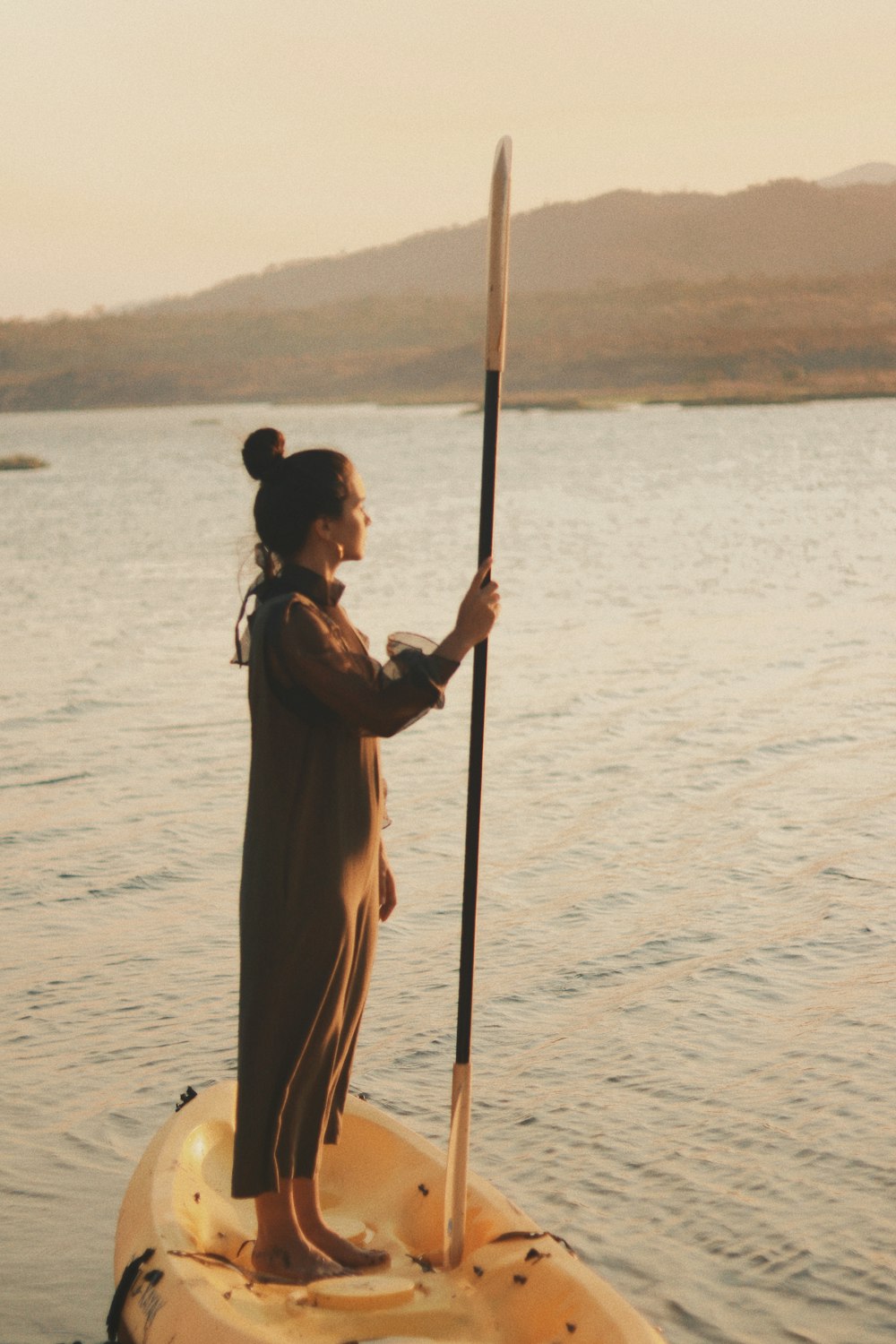 a woman standing on a paddle board in the water