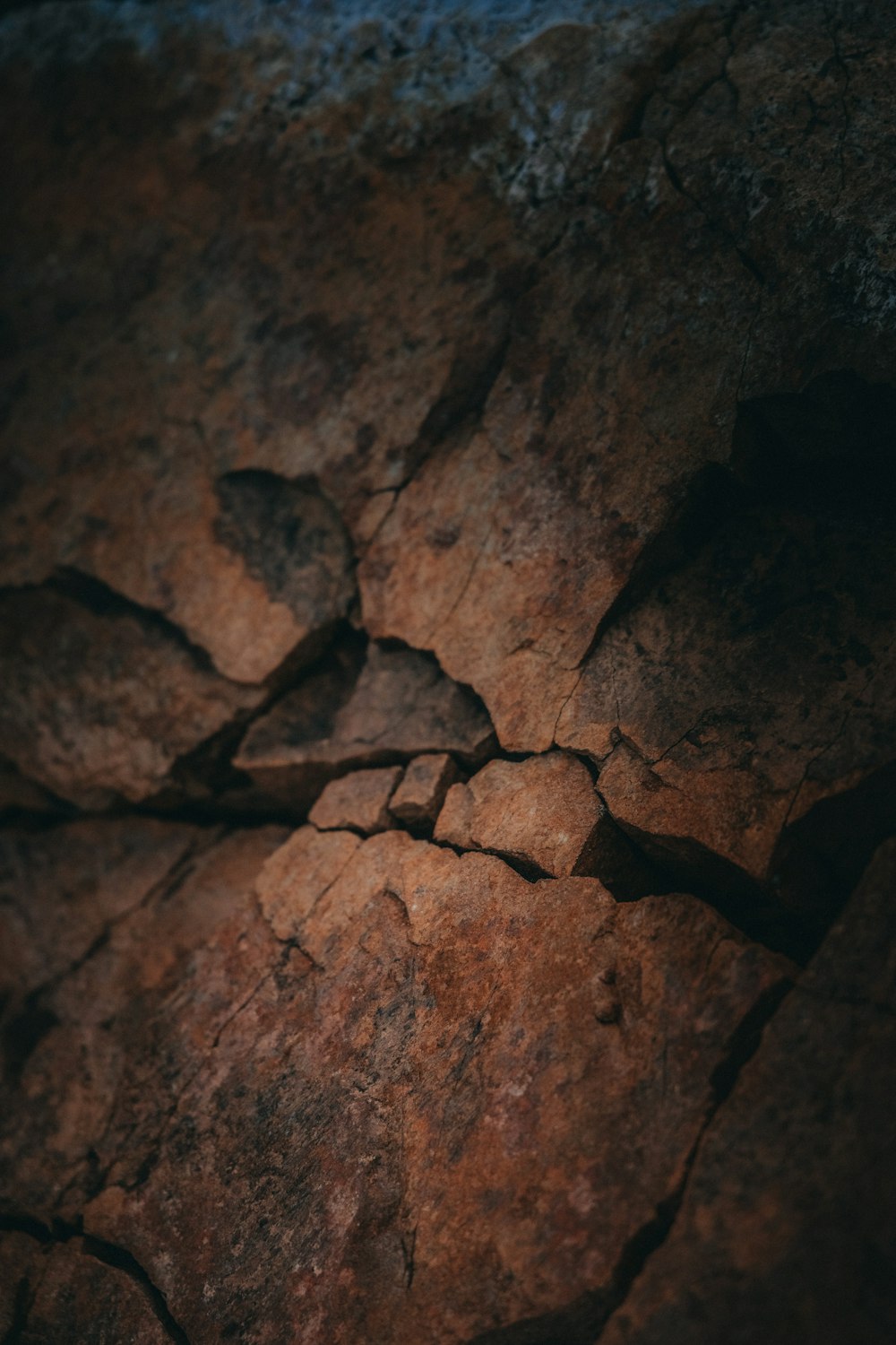 a close up of a rock face with a blue sky in the background