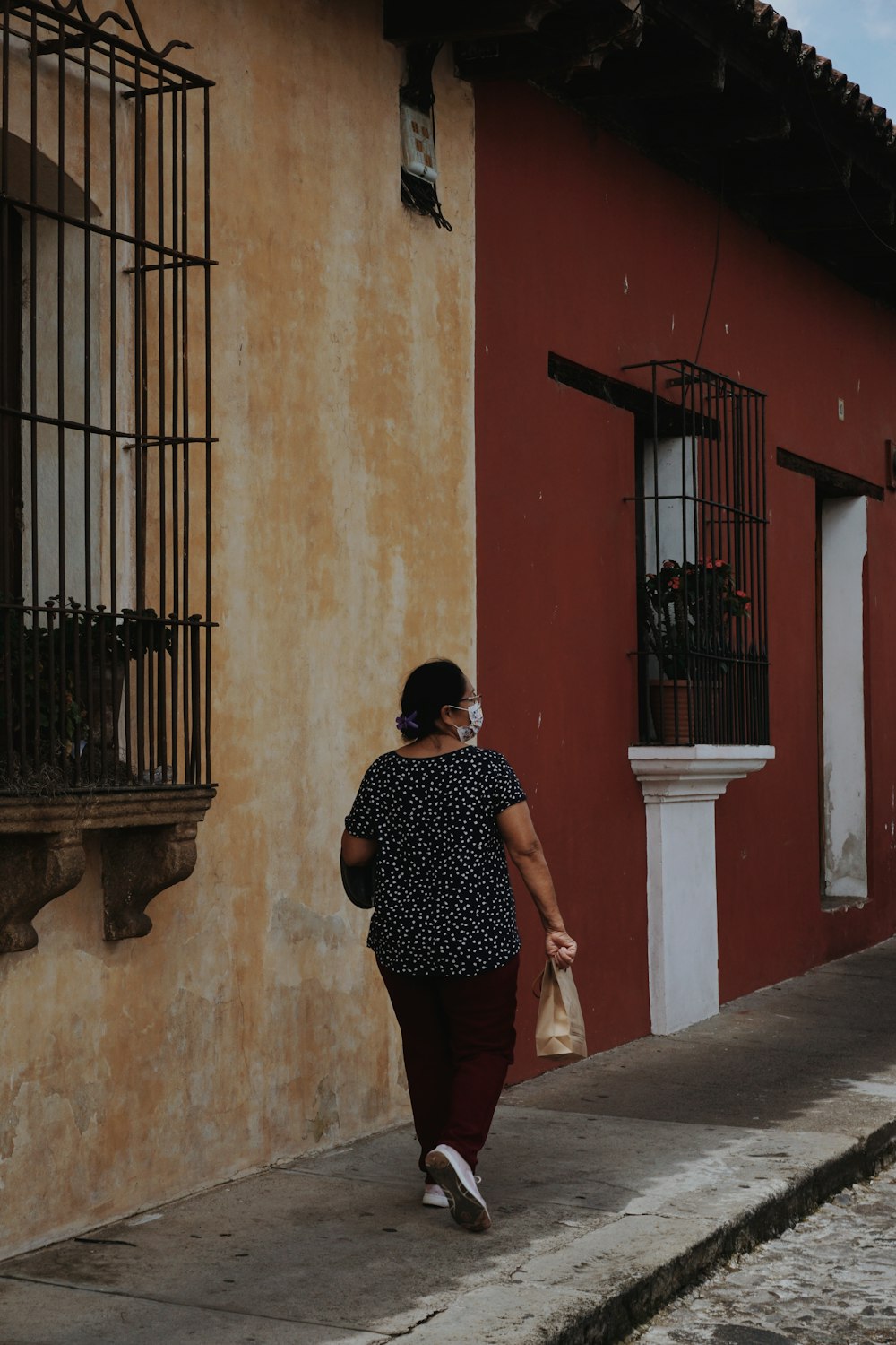 a man walking down a sidewalk next to a building