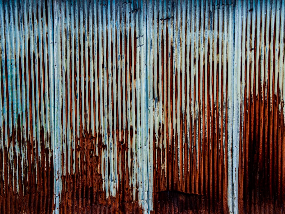 a rusted metal wall with a blue sky in the background