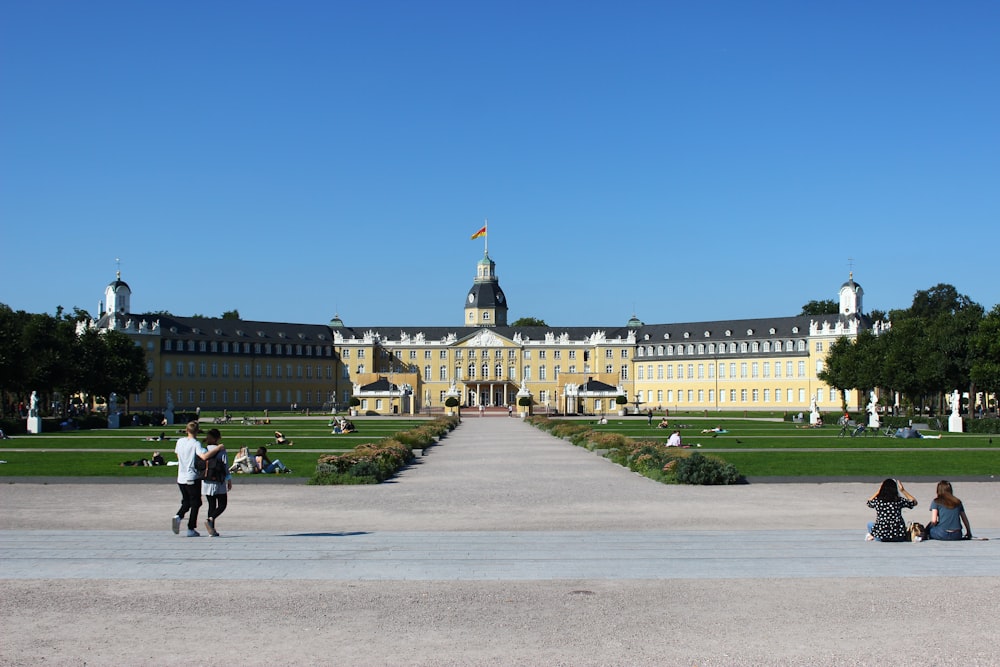 a group of people sitting on the ground in front of a building