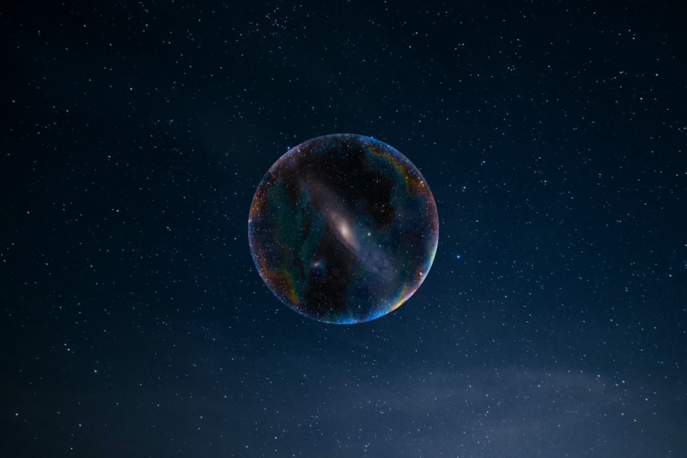 a large bubble floating in the air with stars in the background