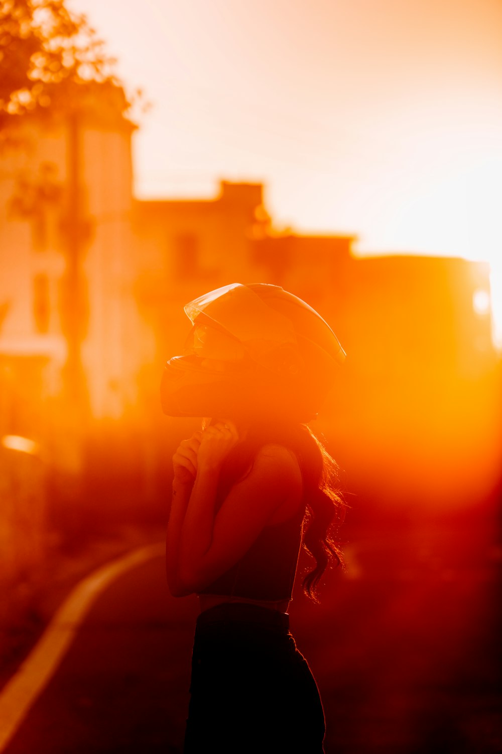 a woman wearing a helmet standing on the side of a road