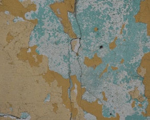 a close up of peeling paint on a wall