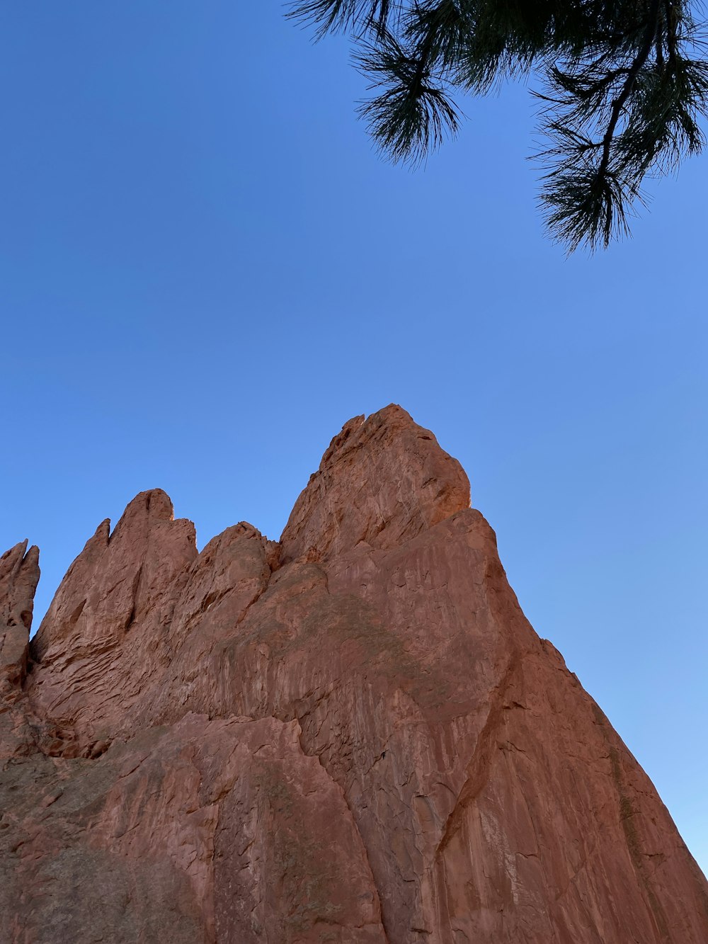 a tall rock formation with a sky in the background