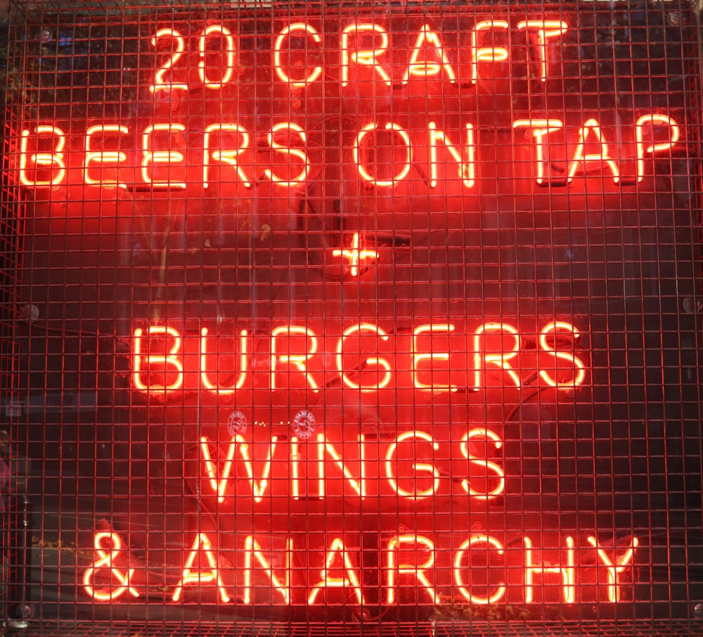 a neon sign that says 20 craft beers on tap and burgers wings and anarchy