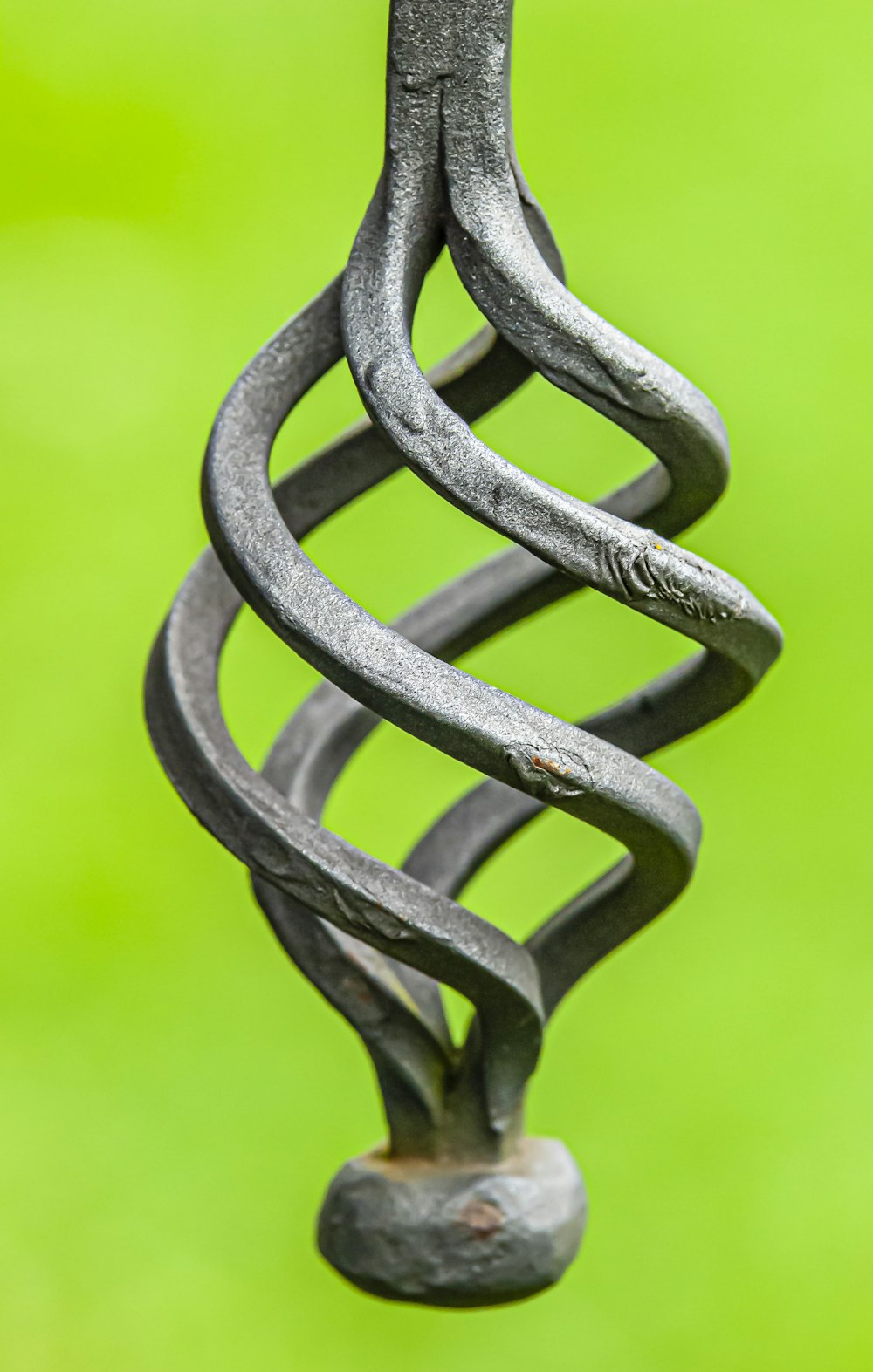 a close up of a metal object with a green background