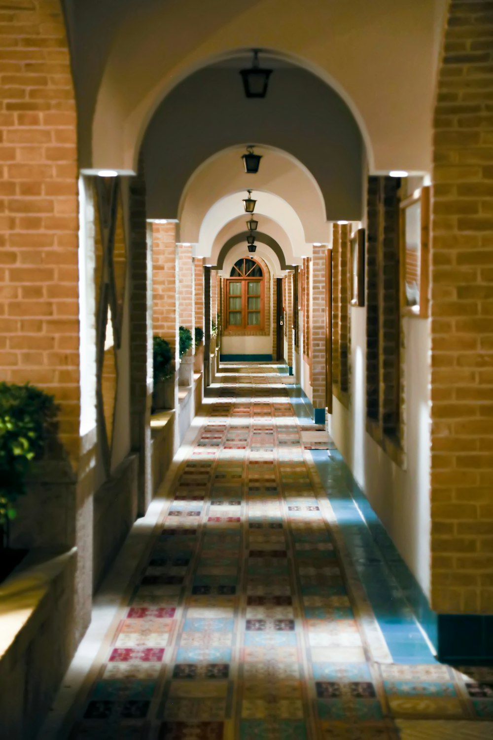 a long hallway with tiled floors and arches