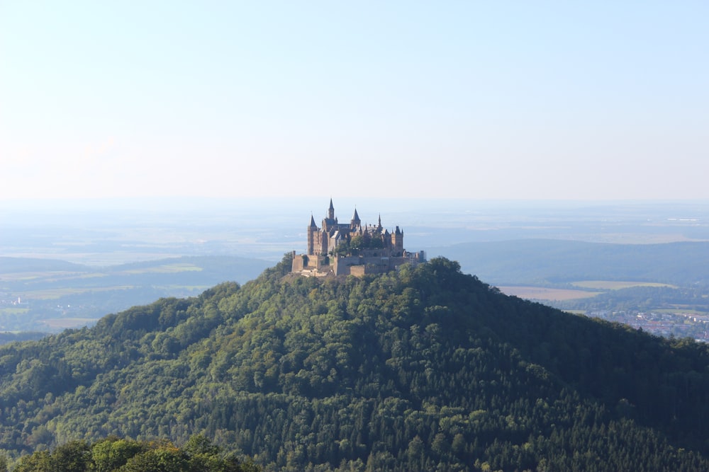 a castle sitting on top of a lush green hillside