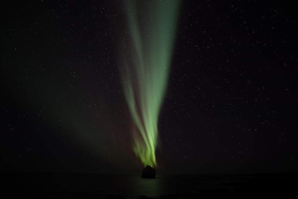 a bright green light shines in the night sky