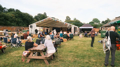 a group of people sitting on top of a lush green field