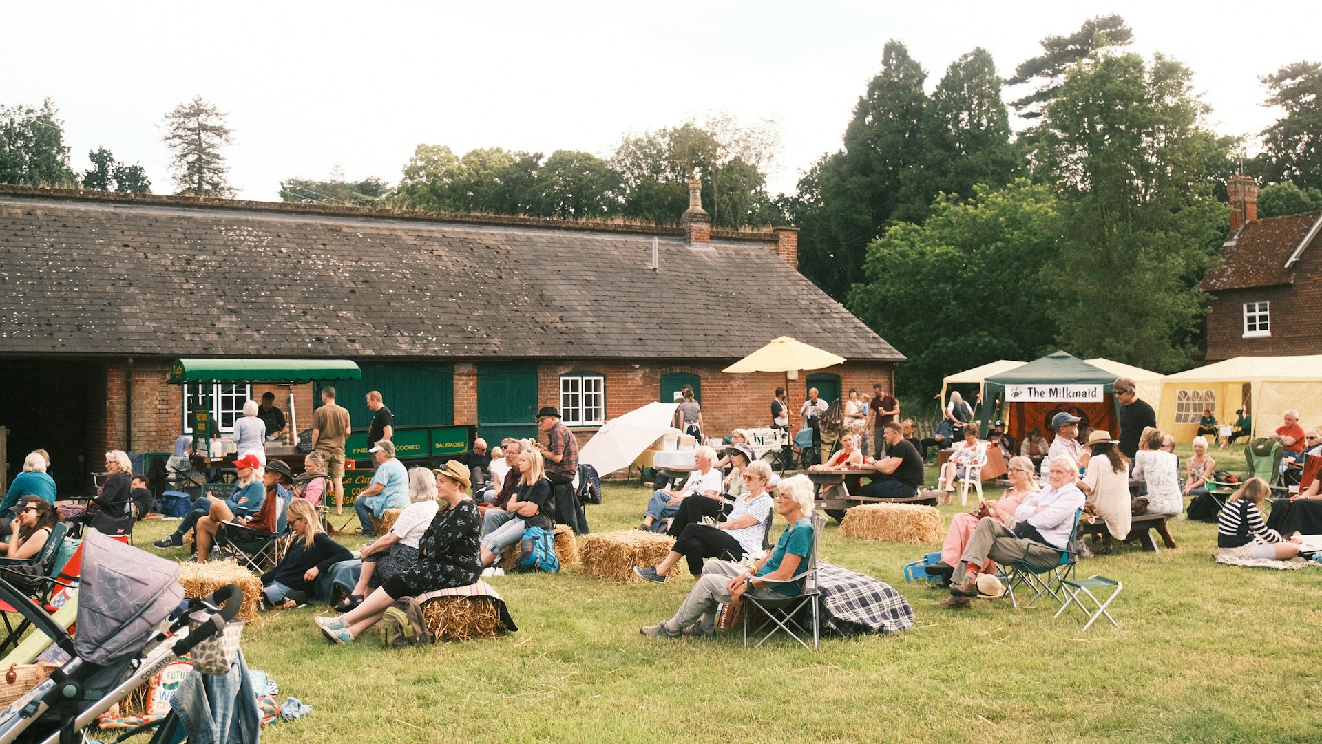 a group of people sitting on hay bales in a field