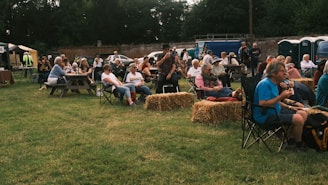 a group of people sitting in chairs in a field