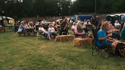 a group of people sitting in chairs in a field