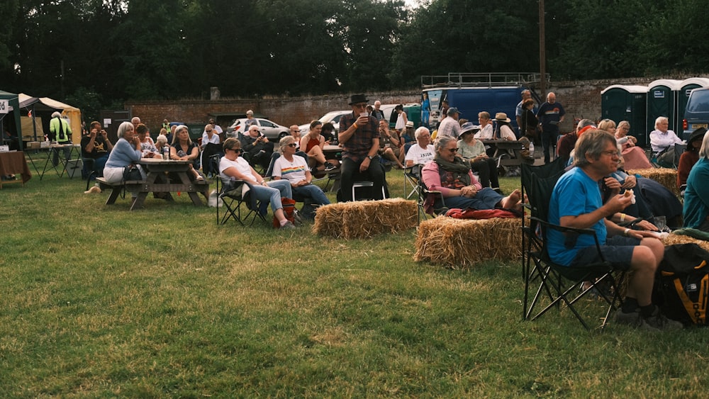 a group of people sitting in chairs in a field