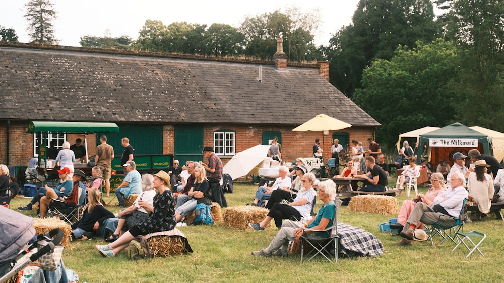 a large group of people sitting on hay bales