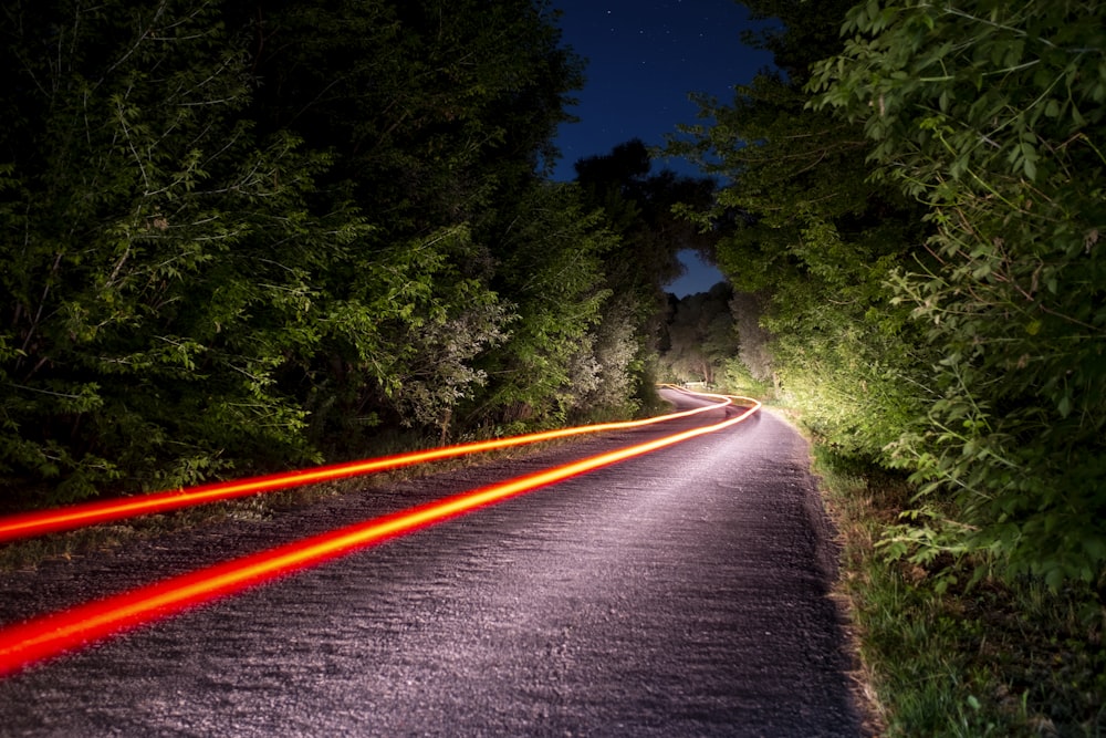 a long exposure photo of a road at night