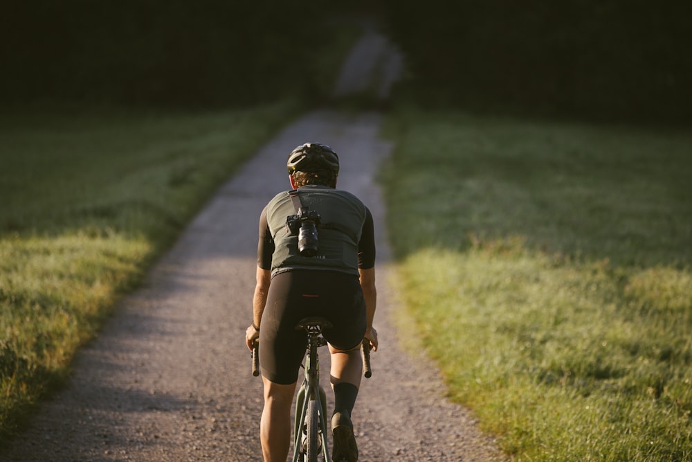 a man riding a bike down a dirt road