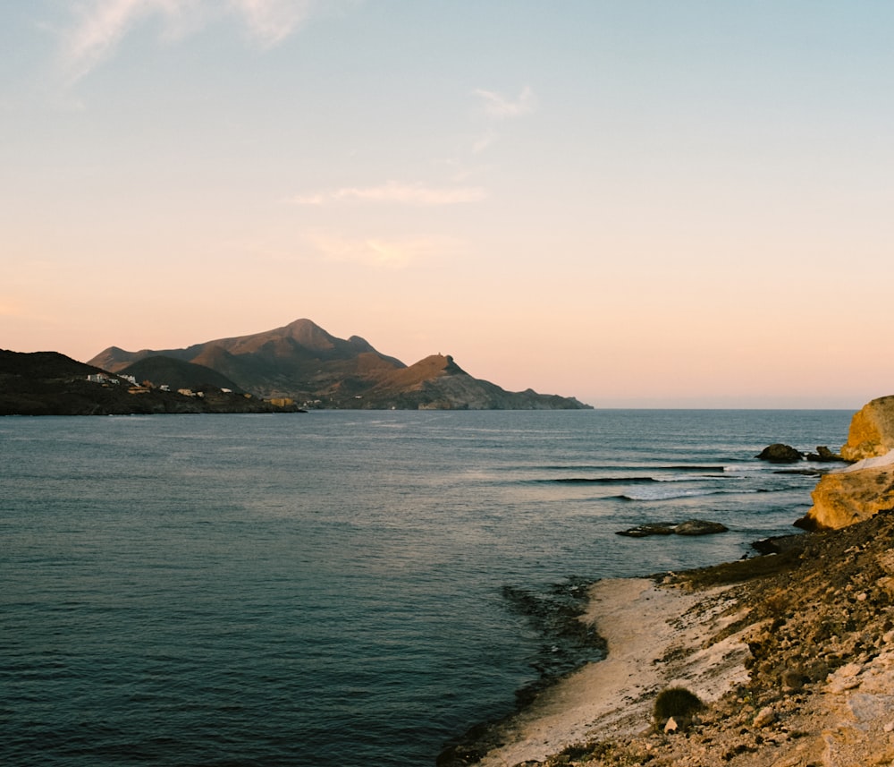 a body of water with mountains in the background