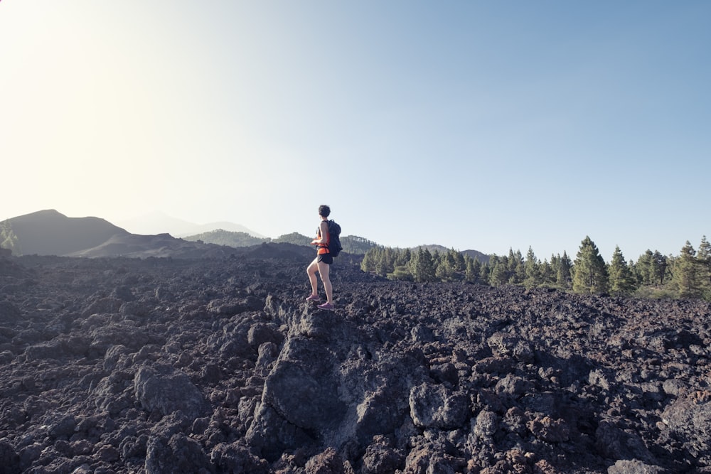 a man standing on top of a rocky hill