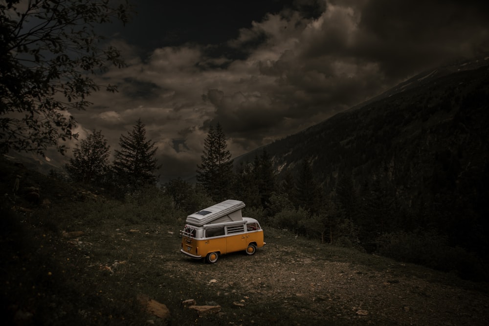 a yellow and white van parked in the middle of a forest