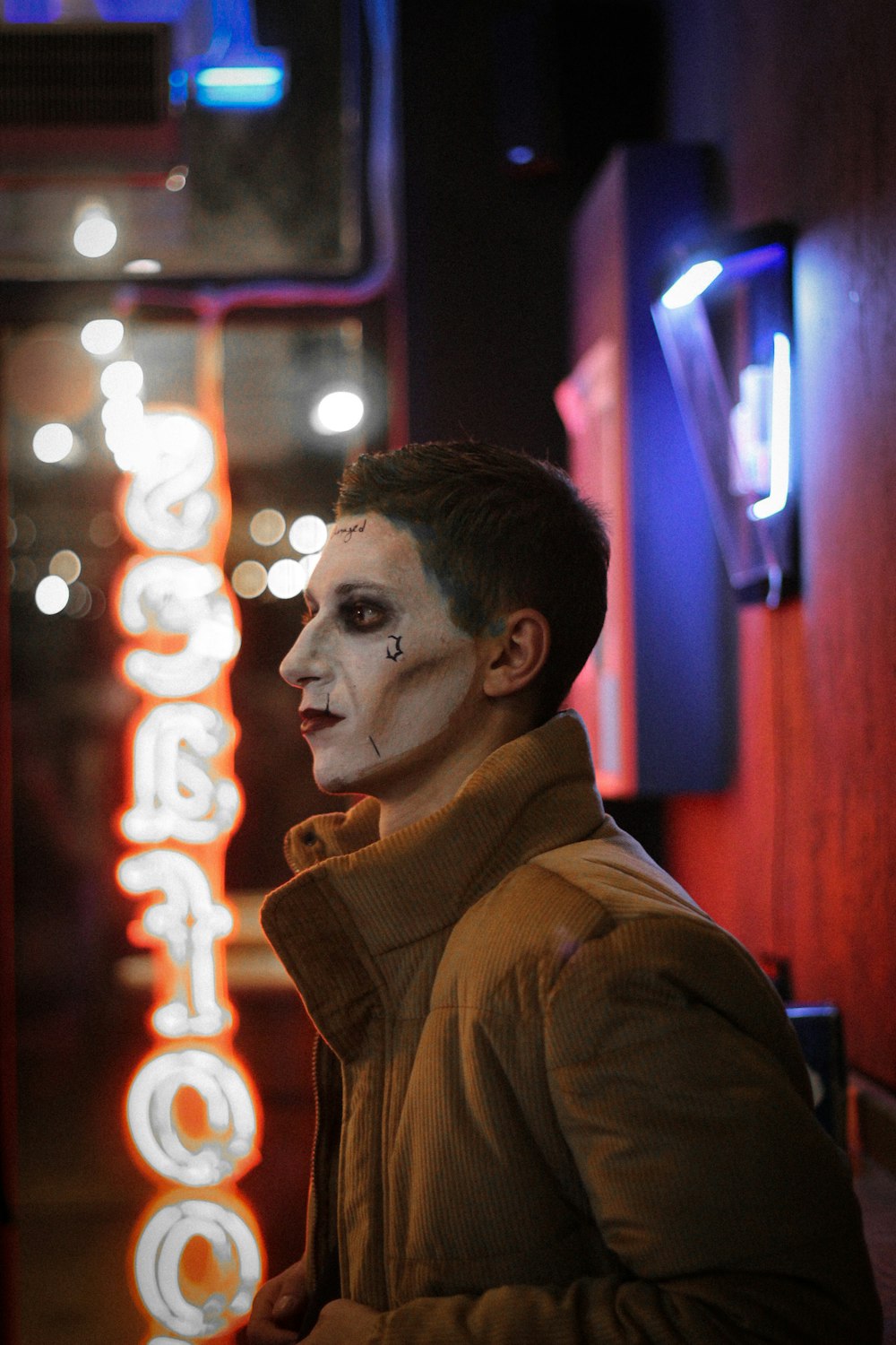 a man wearing a white face paint and a brown jacket