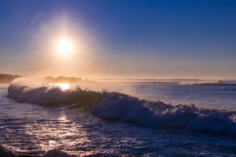 the sun is shining over the ocean with waves