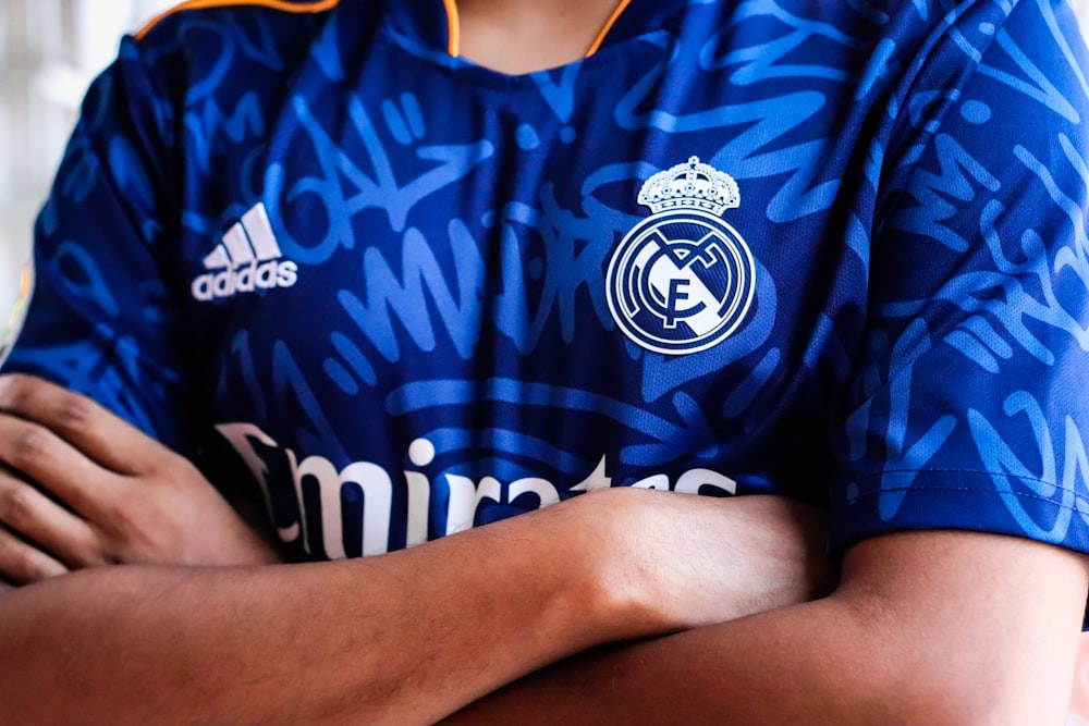 Un hombre con una camisa azul con los brazos cruzados