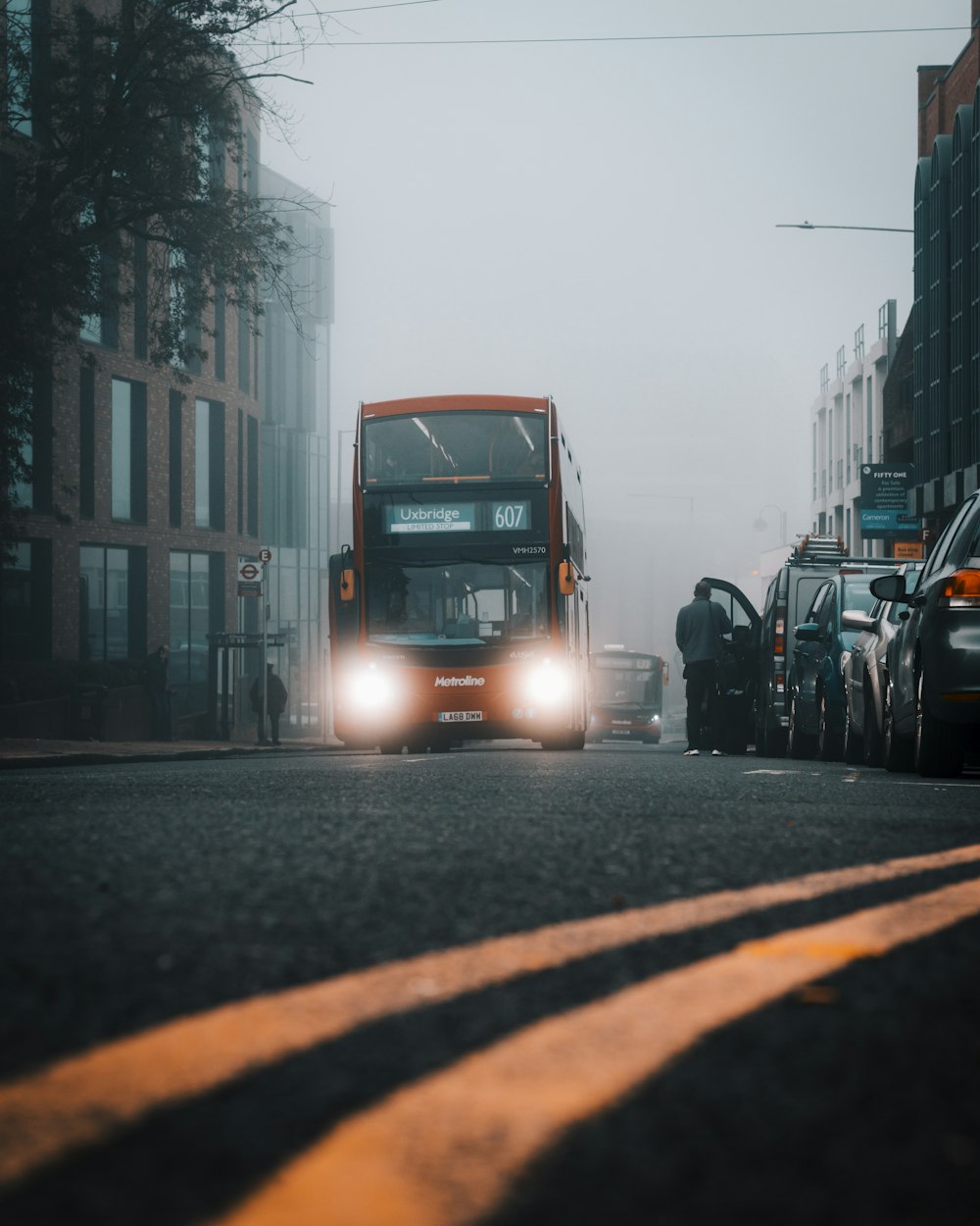 Un bus rouge à impériale descendant une rue