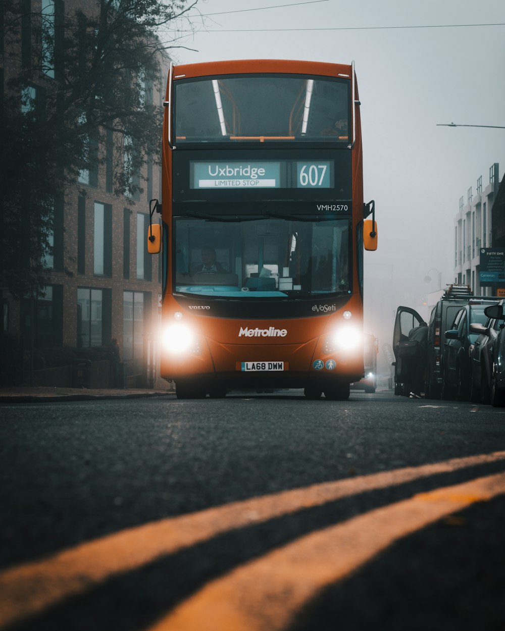 a red double decker bus driving down a street