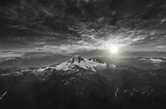 A sweeping landscape shot of a remote mountain range at sunrise, evoking a sense of adventure.