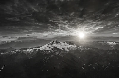 A sweeping landscape shot of a remote mountain range at sunrise, evoking a sense of adventure.