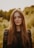 a woman with long hair standing in a field