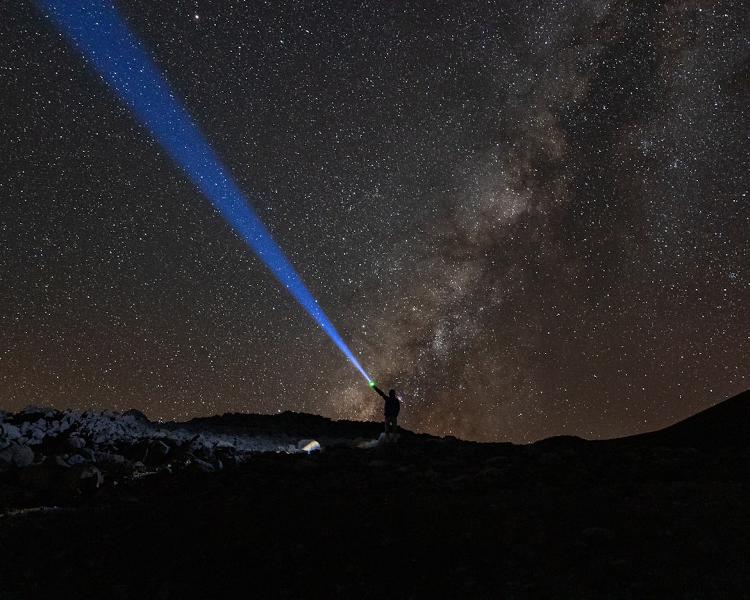 a man standing on top of a mountain under a sky filled with stars, Mauna Kea, Hawaii, USA<p></figure>13,796