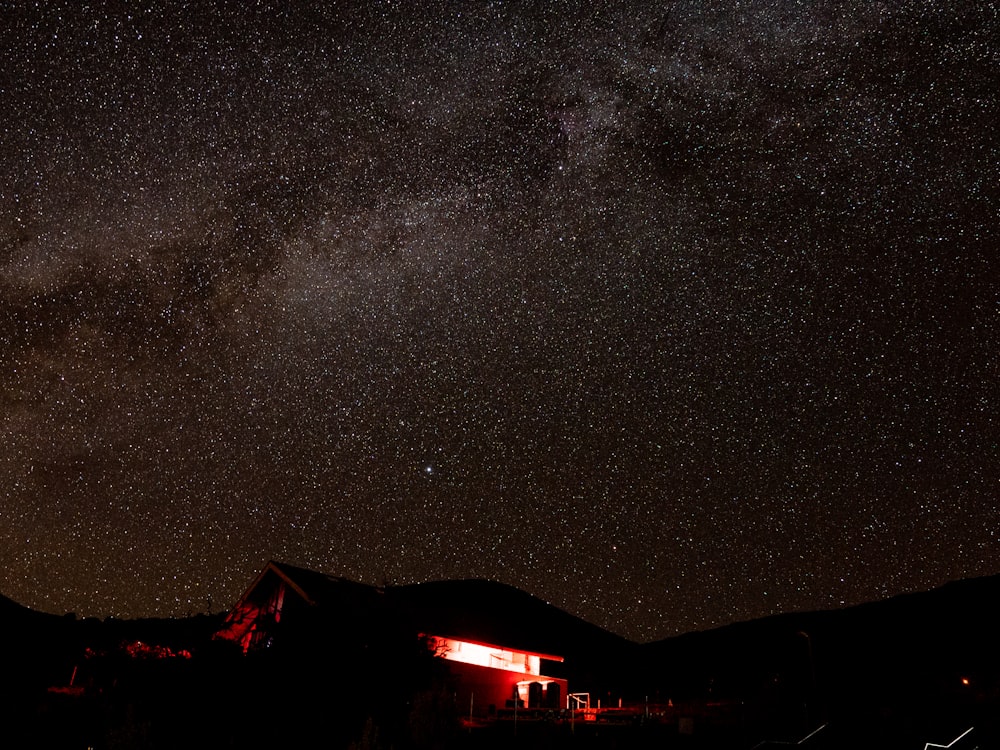 the night sky is filled with stars and a house