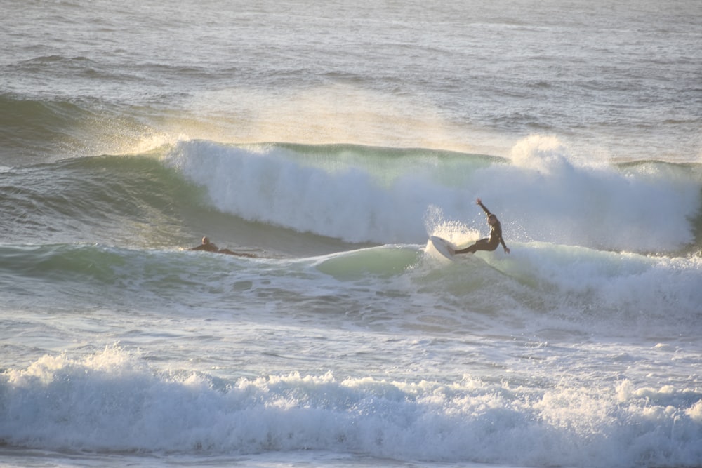 a man riding a wave on top of a surfboard