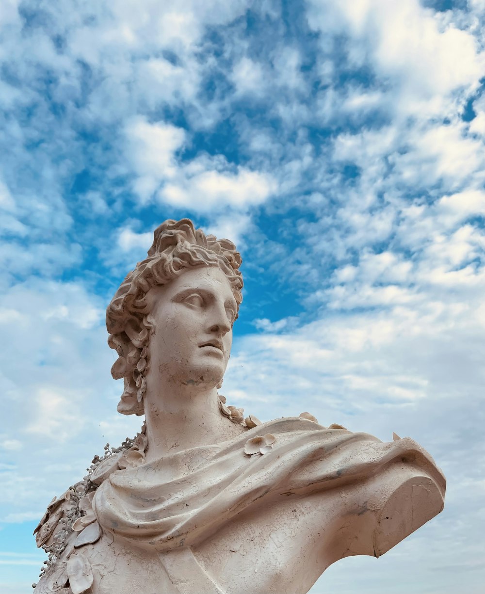 a statue of a woman with a blue sky in the background