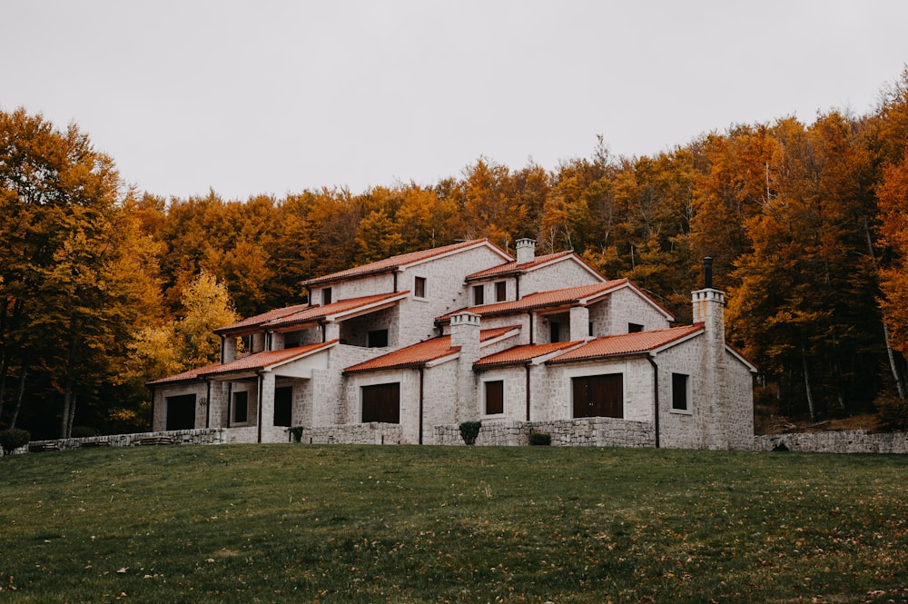 a house in the middle of a field with trees in the background