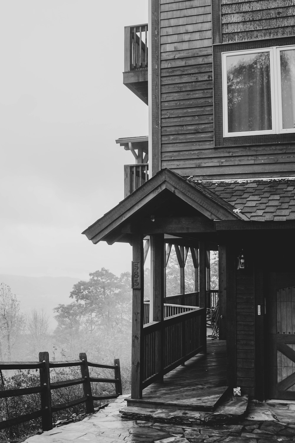 Una foto en blanco y negro de una casa en un día de niebla