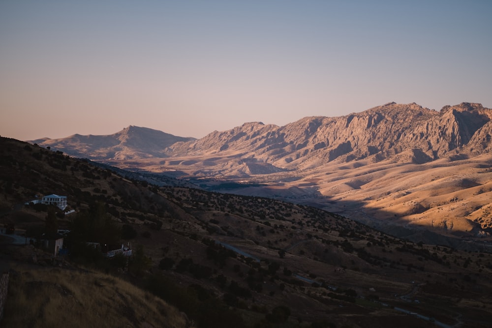 a view of a mountain range with a house in the foreground