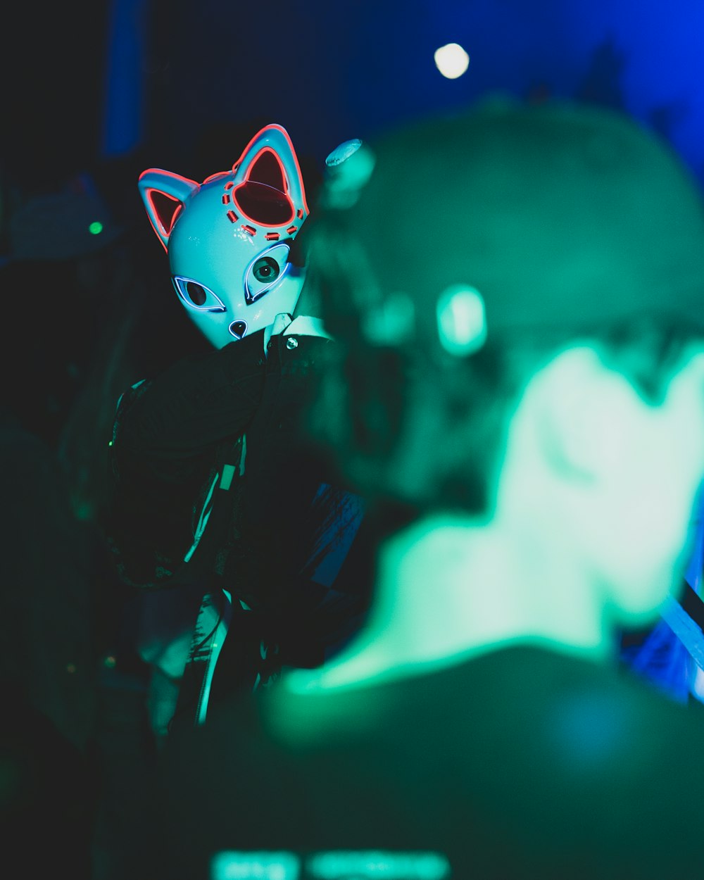a person wearing a cat mask in a dark room