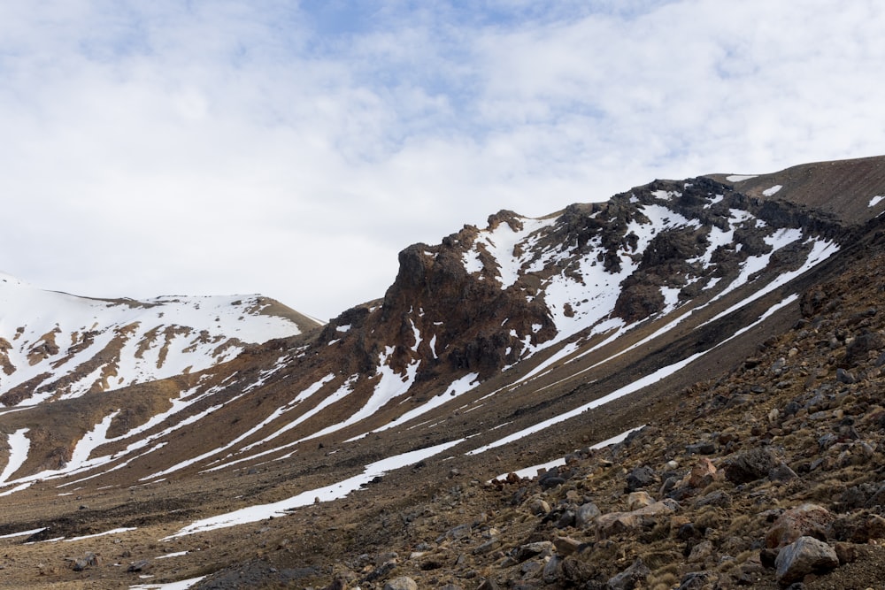 a rocky mountain with snow on the top