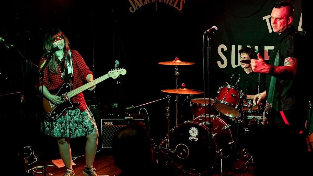 a man and a woman playing guitars on a stage