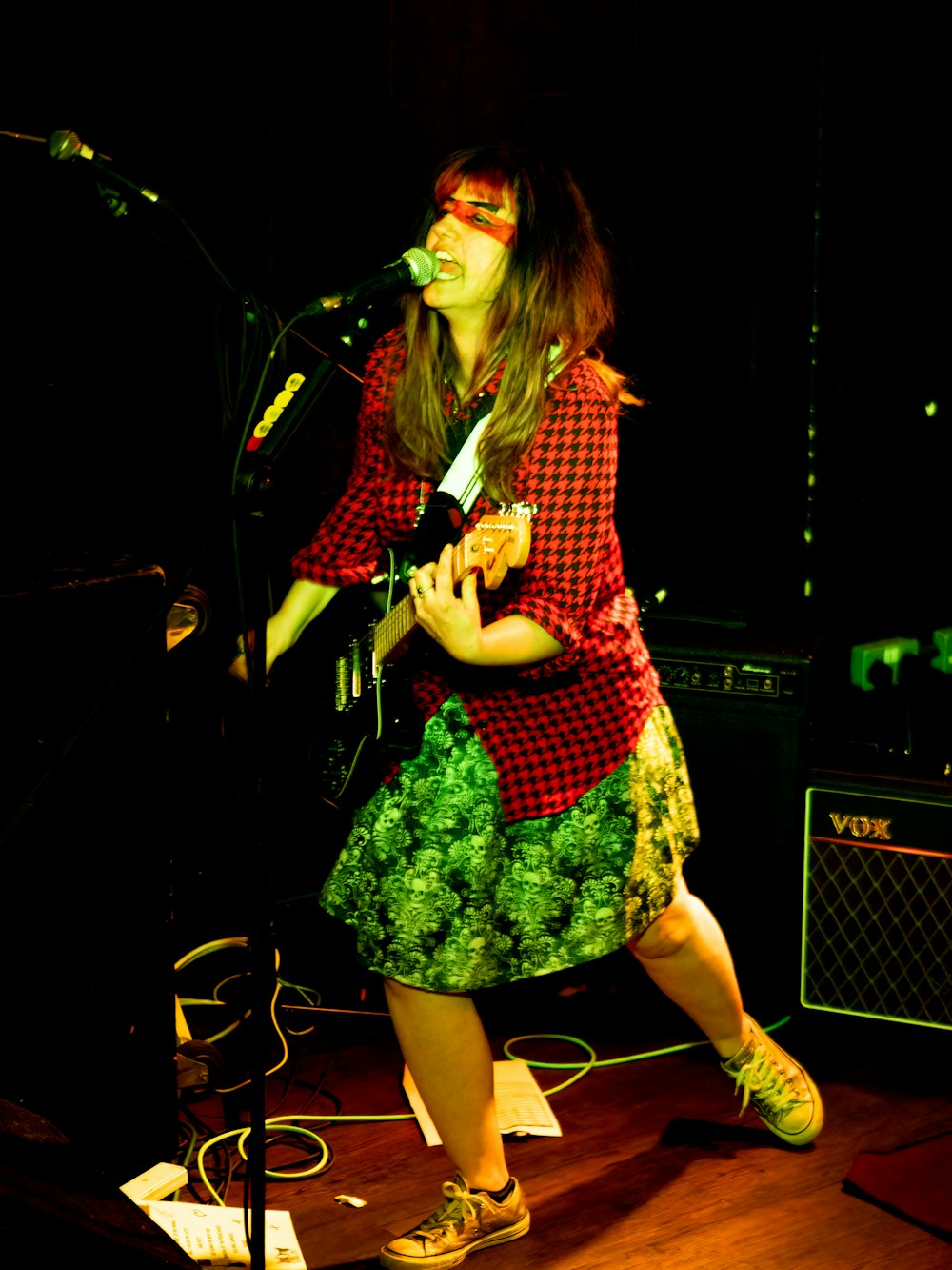 a woman standing on a stage singing into a microphone