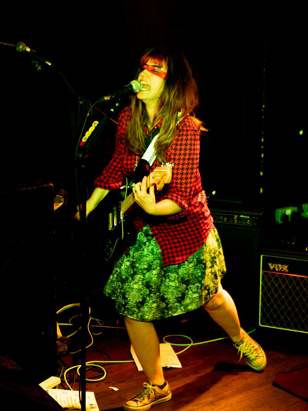 Una mujer parada en un escenario cantando en un micrófono