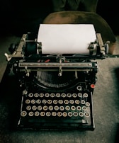 A vintage typewriter with a fresh sheet of paper ready to write.