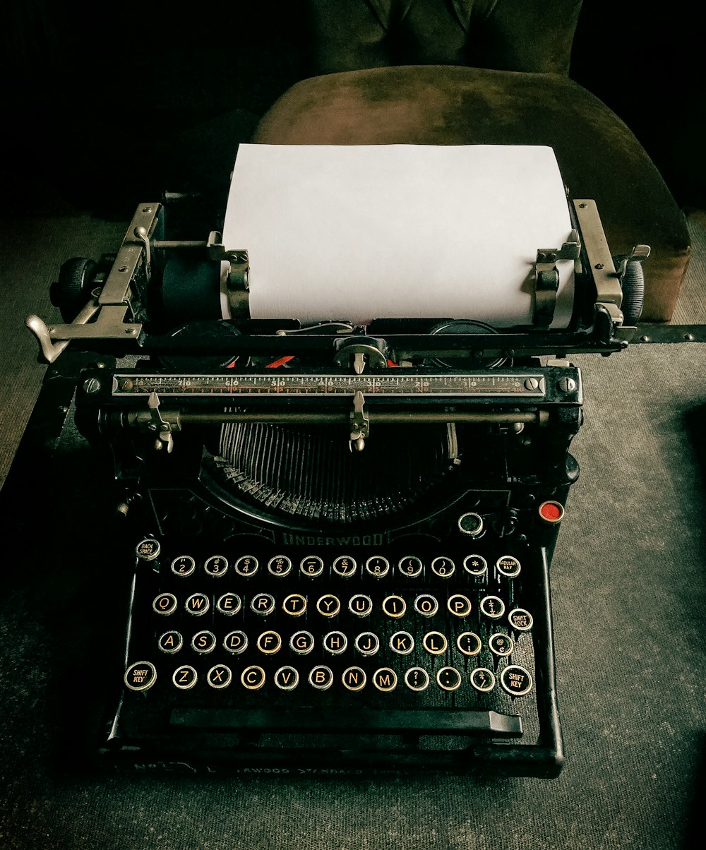 une machine à écrire à l’ancienne avec une feuille de papier par-dessus