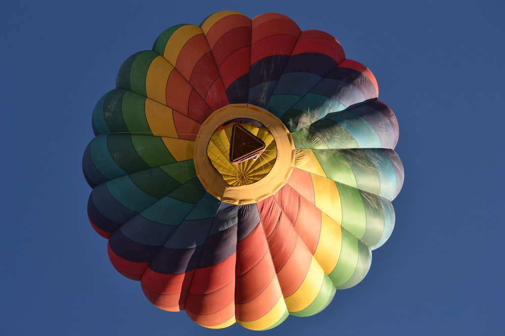 a colorful hot air balloon flying in a blue sky