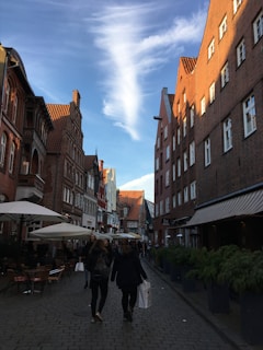 A charming European cobblestone street lined with cafes and historic buildings under a clear blue sky